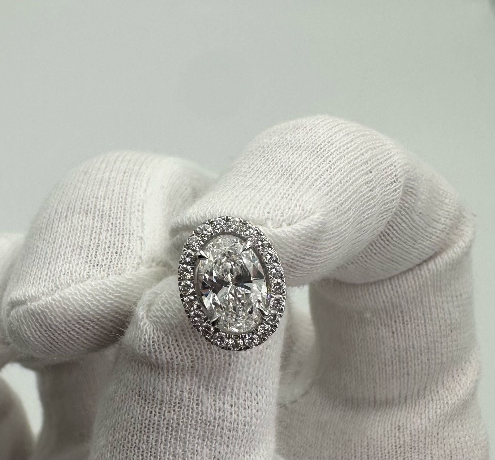 Diamond ring on a white cushion with a light gray background